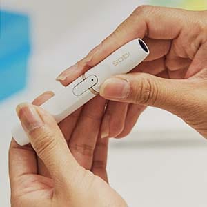 Руки держат держатель IQOS 2.4 PLUS.