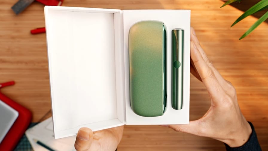 IQOS ILUMA turētājs un portatīvais lādētājs kastē.