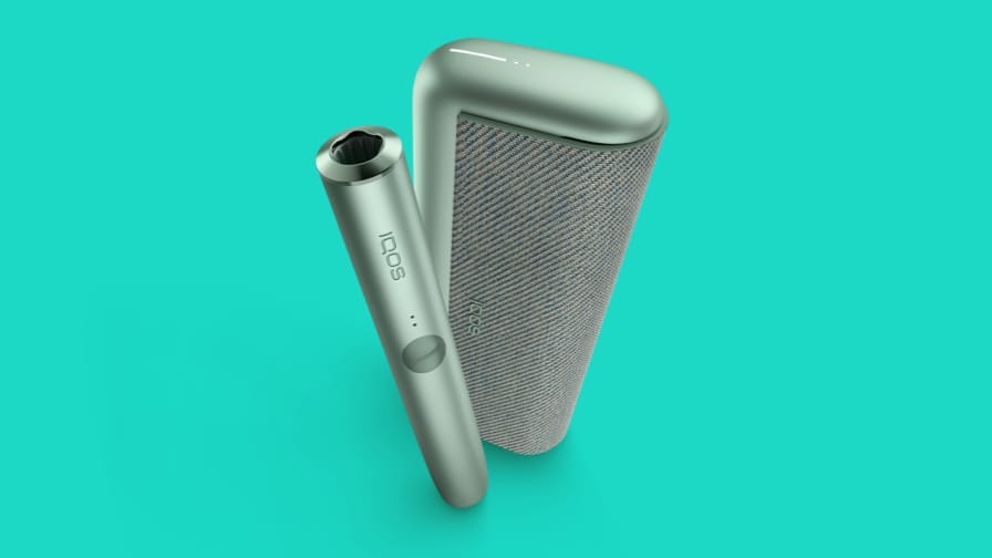 IQOS ILUMA PRIME Green Moss krāsā un tirkīza fonā.