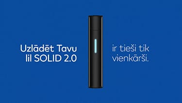 Stone Grey lil SOLID 2.0 ierīce ar spīdošu uzlādes LED gaismu uz zila fona