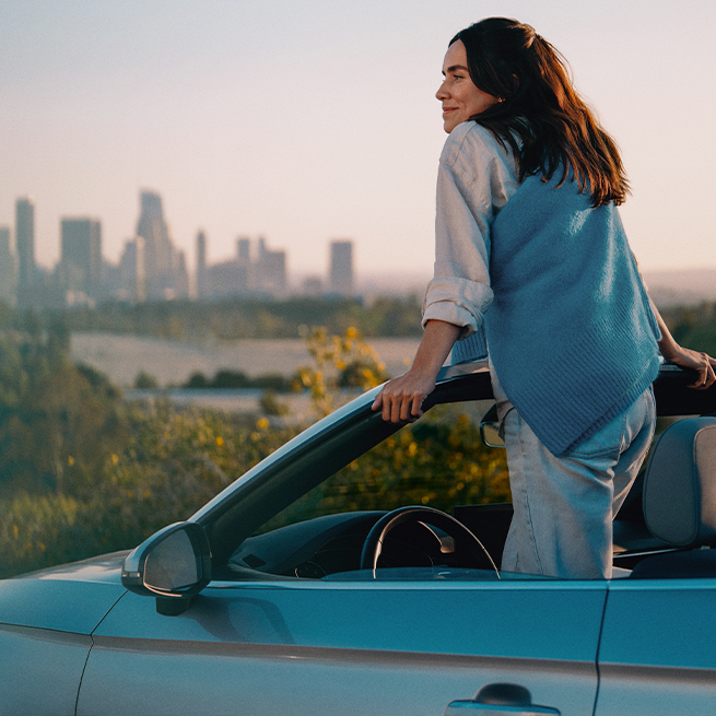 IQOS ILUMA ierīce Moss Green krāsā novietota automašīnā.