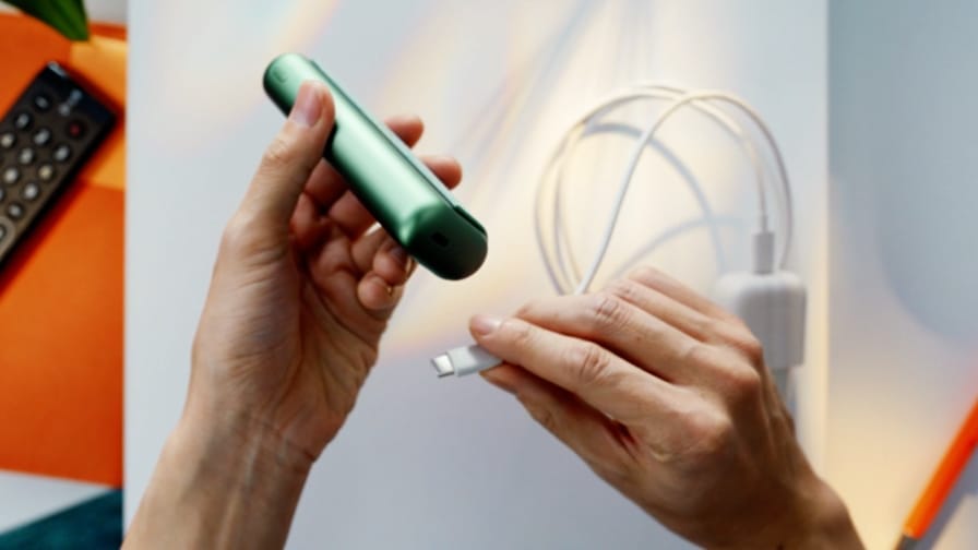 Зарядный кабель вставляется в держатель IQOS ILUMA PRIME.